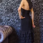 fusta neagta conica cu volane suprapuse vazuta din spate